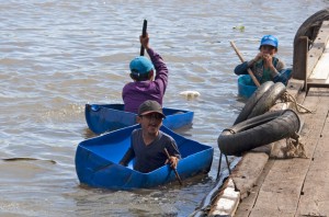 Kids in oil drum boats